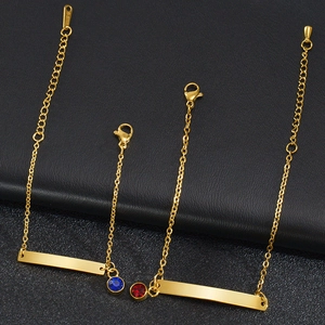 Detalle de pulseras de barra de acero inoxidable dorado con circonitas azules y rojas