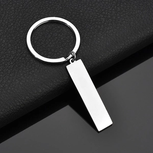 Macro shot of silver stainless steel rectangular pendant keychain on black background