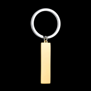Detail view of a polished stainless steel keychain with silver ring and gold rectangular tag