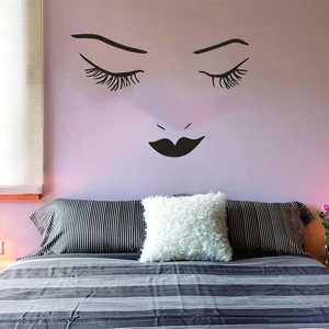 Modern black wall decal with long eyelashes and lips on a minimalist bedroom background
