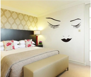 Modern black vinyl wall sticker showing minimalist female eyelashes and lips on white wall