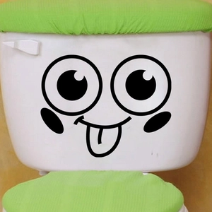 Close-up of a funny cartoon face toilet sticker with a green knitted seat cover