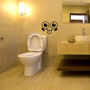 Close-up of a funny black cartoon smiley face waterproof decal on a bathroom wall