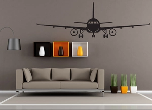 Detailed close-up of a black minimalist airplane silhouette wall sticker above a sofa