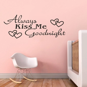 Detail view of Always Kiss Me Goodnight black wall decal with heart accents on pink wall