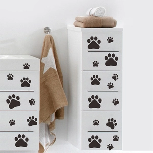 Détail de stickers muraux pattes noires appliqués sur une commode blanche moderne
