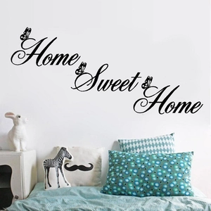 Home Sweet Home script wall decal with butterfly accents in a cozy bedroom setting