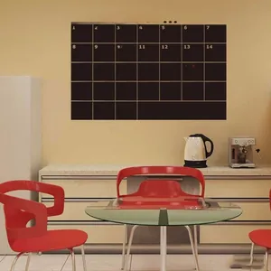 Gros plan du calendrier mensuel noir autocollant pour tableau mural sur un mur jaune