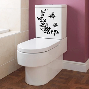 Detail view of black floral vine and butterfly PVC wall sticker on a white toilet tank