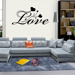 Black Love wall decal with vine and heart motifs on a living room sofa background