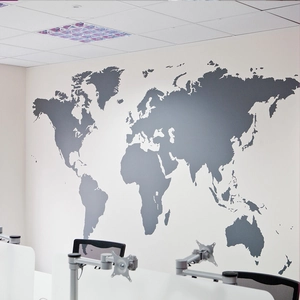 Detailed view of dark grey world map wall decal installed in a modern office setting