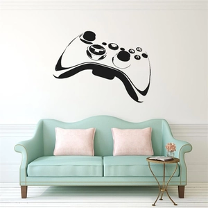 Gros plan d'un sticker mural manette de jeu noire avec boutons XYAB sur mur blanc