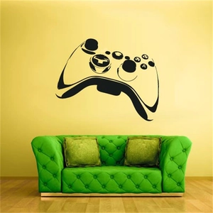 Détail d'un sticker mural manette de jeu noir minimaliste sur un fond de mur jaune vif