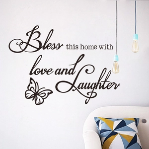 Bless this home with love and laughter wall decal with butterfly in a modern living room
