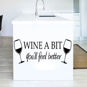 Detail of 'WINE A BIT' black vinyl wall sticker on a modern white kitchen island surface