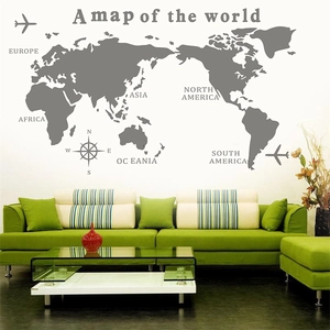 Detailed view of grey world map wall decal with geographic labels above a green sofa