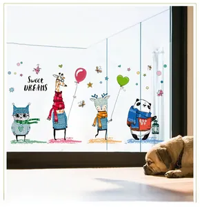 Close-up of animal wall decals featuring owls and pandas on a warm glass door surface