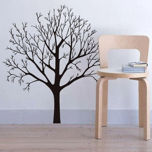 Dettaglio di un adesivo murale con sagoma di albero nero su una parete bianca di design moderno