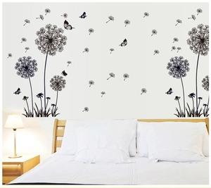 Close-up of black dandelion and butterfly wall stickers on a cozy bedroom wall