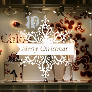 Christmas window decals showing festive white lettering on a glass storefront display
