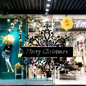 Detail of black Merry Christmas wall sticker with snowflake patterns on shop window