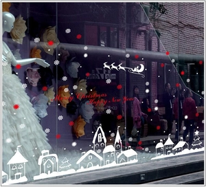 Christmas window stickers with white snowflakes and red reindeer pulling santa over a snowy town