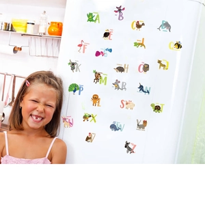 Cartoon alphabet stickers with animals on white fridge with a smiling girl