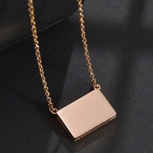 Detailansicht eines minimalistischen rechteckigen Anhängers aus Roségold an einer O-Kette