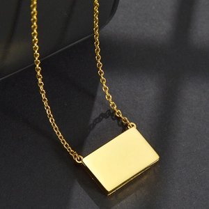 Detail eines minimalistischen goldenen Rechteck-Anhängers mit glatter Spiegelfläche
