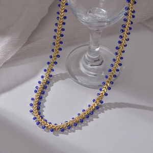 14K gold-plated stainless steel chain necklace with dark blue faceted beads on white fabric