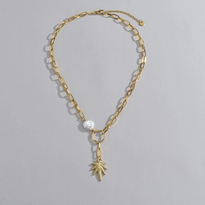 Collana retrò francese in oro 14K con pendente a foglia e perle su sfondo grigio