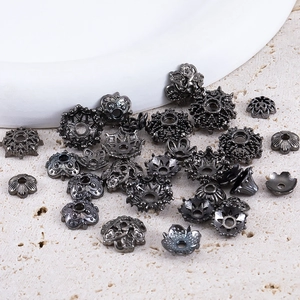 Gunmetal flower bead caps for DIY jewelry making on a decorative stone base