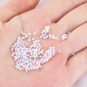 Mischung aus 2mm Makronen Glasperlen mit Perlglanz-Finish für DIY Schmuck in der Hand