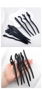 Detail showing a collection of matte black sandalwood hair sticks in diverse cloud patterns