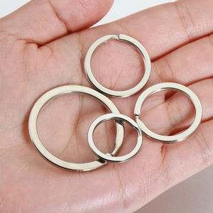Flat iron double key rings in four sizes shown on palm for scale with silver finish
