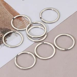 Flat silver metal split key rings with polished finish on textured fabric background