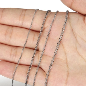 Polished stainless steel cross chains in four thickness sizes held in a palm for scale