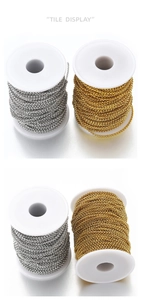 Close-up of gold and silver plated stainless steel bead chains on white plastic spools