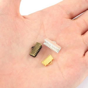 DIY ribbon crimp ends in gold, silver and bronze held in palm showing varied sizes
