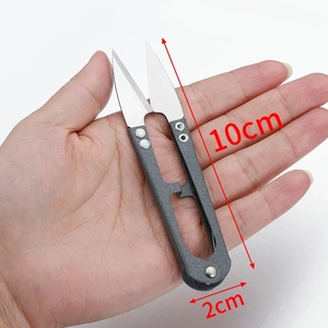 U-shaped stainless steel thread snips scissors 10cm x 2cm shown in hand for scale