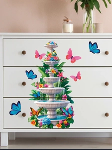 Détail de stickers muraux papillons et fontaine appliqués sur des tiroirs d'armoire blancs