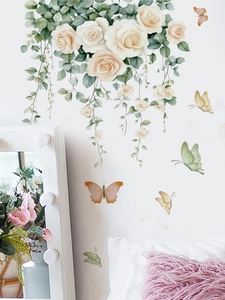 Close-up of white rose and colorful butterfly PVC wall stickers in a cozy bedroom setup