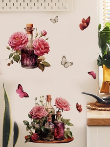 Detail of pink rose and butterfly PVC wall sticker on a vintage glass bottle