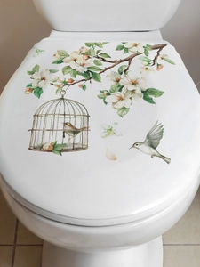 Detail of floral wall sticker with birds and birdcage on a white toilet cover