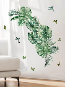 Macro detail of tropical monstera leaves and hummingbird wall decals on white background