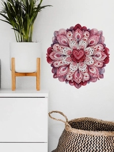 Detalle de un adhesivo de pared mandala redondo con corazones rojos en pared blanca