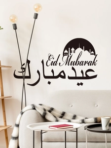 Detail of black Eid Mubarak wall stickers with mosque silhouettes on a white living room wall