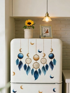 Détail de stickers muraux attrape-rêves et lune sur un frigo blanc dans un cadre de cuisine