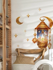 Detail of golden Ramadan star and lantern wall decals on a clean white home interior wall