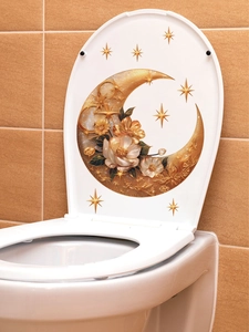 Détail d'un abattant de WC blanc orné d'un croissant de lune doré et de fleurs blanches